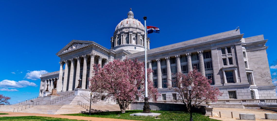 Missouri State Capitol with pink magnolia tree flowers in spring that houses General Assembly and executive branch of the government in Jefferson City