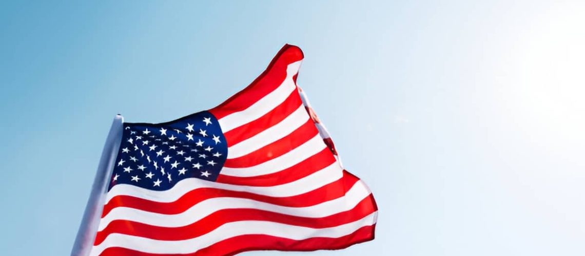 American flag waving against blue sky